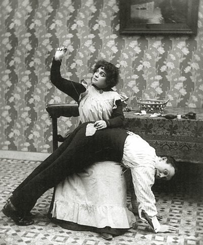 Woman sewing a tear on a mans trousers, c.1895 by American Photographer